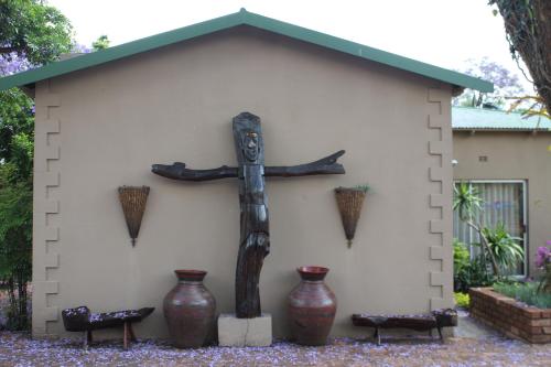 a statue of a cross in front of a building at African Roots Guest House in Polokwane