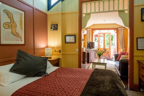 Como Cottage Accommodation في أوليندا: غرفة نوم مع سرير وغرفة معيشة