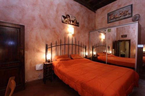 ローマにあるLupa Flatのベッドルーム1室(オレンジのシーツを使用したベッド2台付)