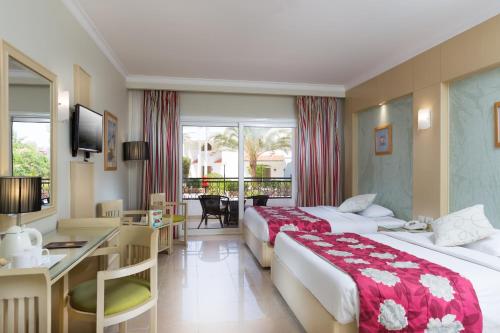 a hotel room with two beds and a desk at Naama Bay Hotel & Resort in Sharm El Sheikh