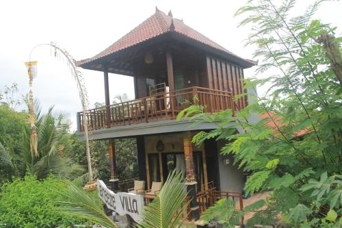 a house with a balcony on top of it at Breeze Villa in Nusa Lembongan