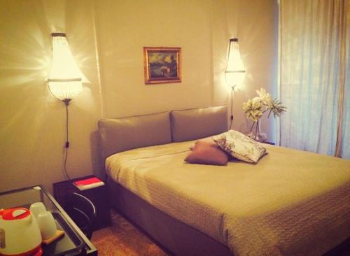 una camera da letto con un letto con due luci sopra di Casa mia a Palermo