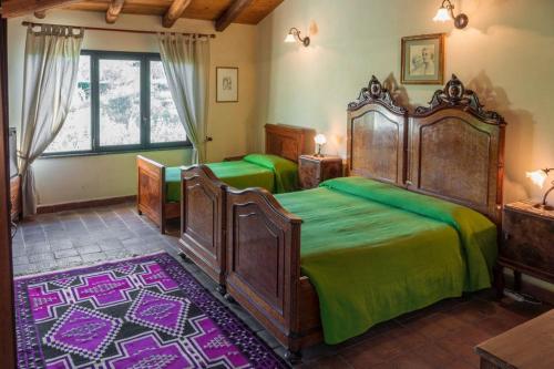 1 dormitorio con 2 camas grandes con sábanas verdes en Bed and Breakfast Il Glicine, en Piedimonte Etneo