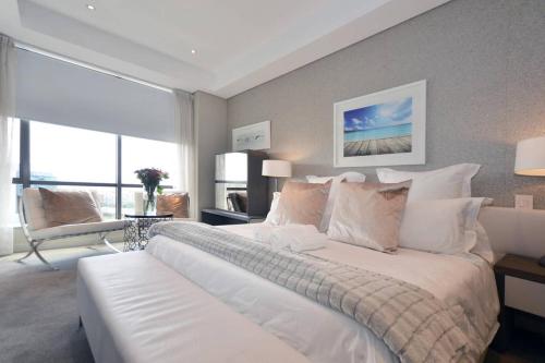 a bedroom with a large white bed with a large window at 615 Sandton Skye in Johannesburg