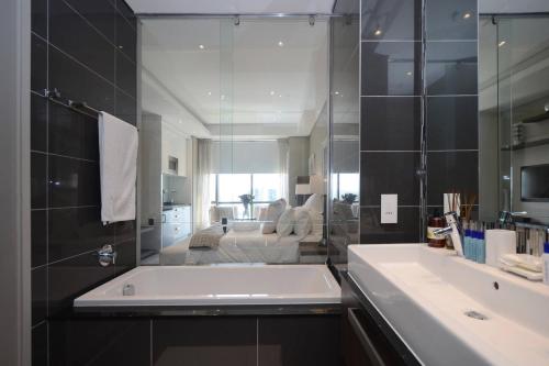 a bathroom with a large tub and a large mirror at 615 Sandton Skye in Johannesburg