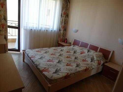 um quarto com uma cama num quarto com uma janela em Golden Dreams , appartements Mira em Sunny Beach