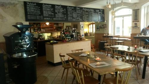 un restaurante con mesas y sillas y un menú en la pared en K-Hotel (Grüner Baum), en Überlingen