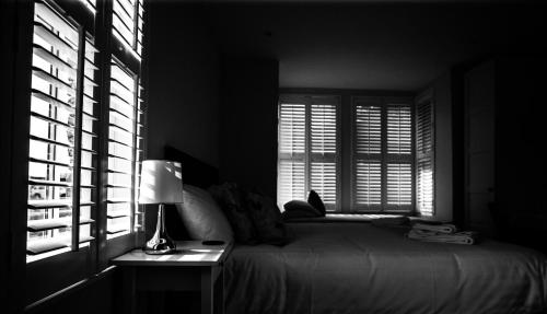 a bedroom with a bed and a lamp and windows at Bridge Hotel Brandon in Brandon