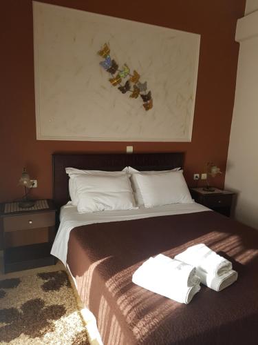 a bedroom with a bed with two towels on it at Xenonas Arxontiko in Kato Loutraki
