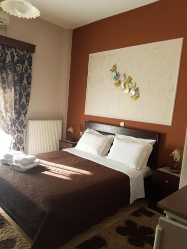 a bedroom with a bed and a painting on the wall at Xenonas Arxontiko in Kato Loutraki