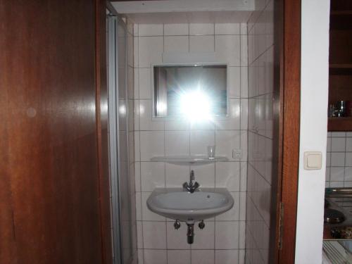 a bathroom with a sink and a light on the wall at Bauernhof Manuela Perner in Nussdorf am Attersee