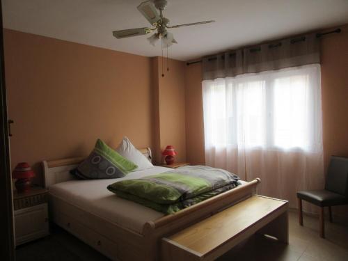 sypialnia z łóżkiem z wentylatorem sufitowym i oknem w obiekcie Ferienwohnung Tropical w mieście La Herradura