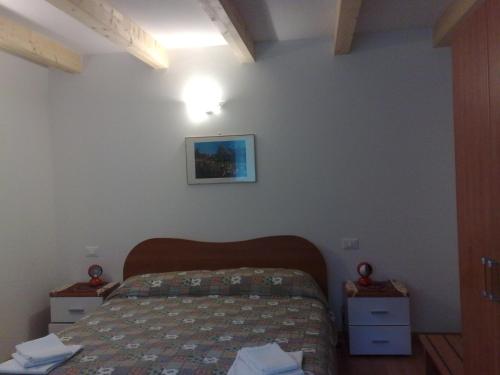 1 dormitorio con 1 cama y una foto en la pared en B&B Tre Faggi, en Borgo
