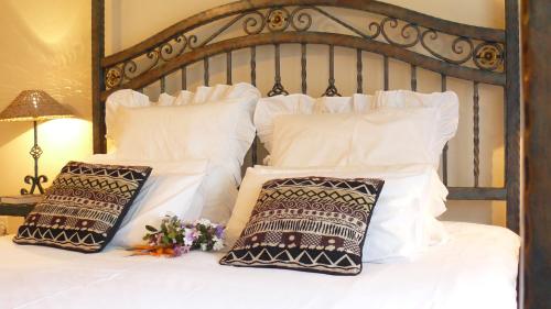 a white bed with white pillows and flowers on it at Crocodile Lodge cc in Midrand