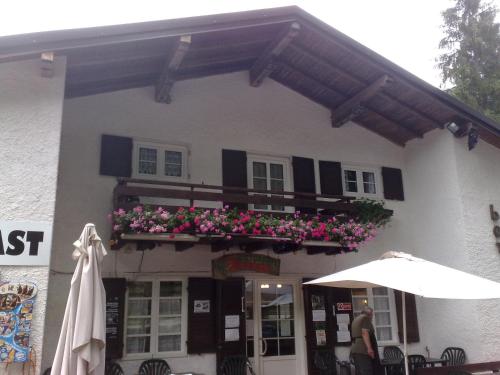 a building with a balcony with flowers and an umbrella at B&B Tre Faggi in Borgo