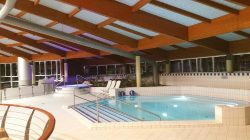 a large swimming pool in a building with a roof at Seeparkpromenade Sellin Wohnung Morgensonne in Ostseebad Sellin
