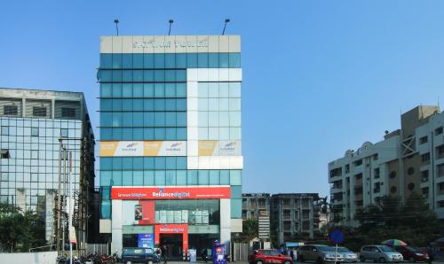 a large glass building with cars parked in a city at Treebo Trend Hoops - Airport in Kolkata