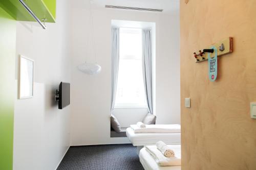 a room with two white beds and a mirror at Maverick Budapest Soho in Budapest