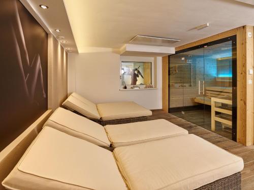 two beds in a room with a bathroom at A-VITA Viktoria & A-VITA living luxury apartments in Seefeld in Tirol