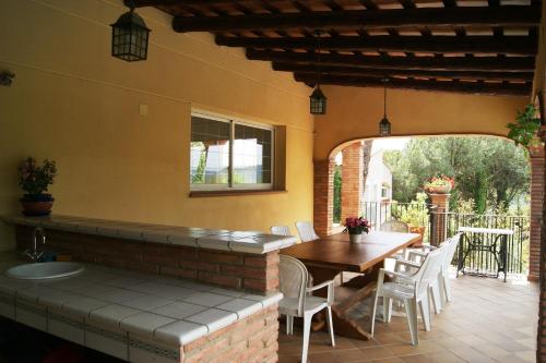 サンタ・クリスティーナ・ダロにあるCasa en la costa Bravaのパティオ(木製のテーブル、椅子、テーブル、テーブル付)