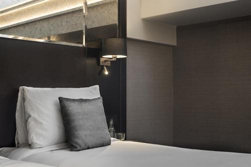 a bedroom with a bed with a pillow on it at Camden Enterprise Hotel in London