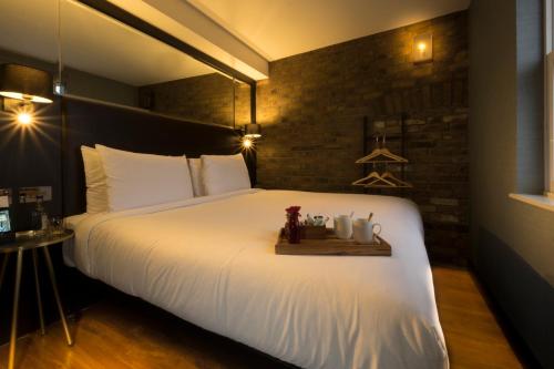 a bedroom with a large white bed with a tray on it at Camden Enterprise Hotel in London