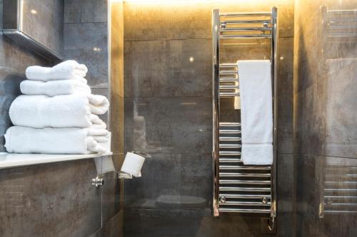 
a bathroom with a rack of towels hanging on the wall at Camden Enterprise Hotel in London
