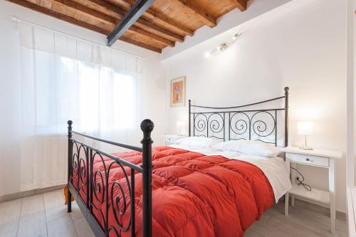 フィレンツェにあるcasa tradizionale toscanaのベッドルーム1室(黒いベッド1台、赤い毛布付)