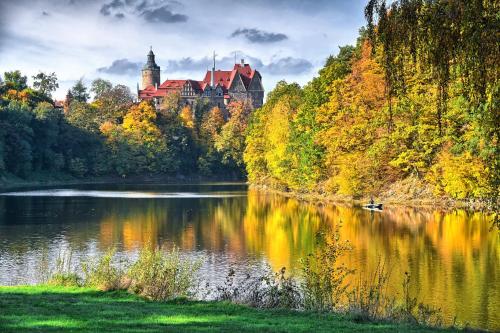 a castle on a hill next to a lake at Zamek Czocha in Leśna