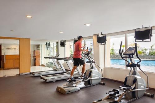 a man walking on a treadmill in a gym at Novotel Semarang in Semarang
