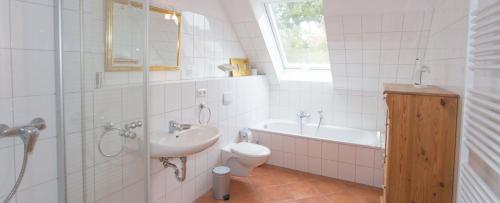 a bathroom with a sink and a toilet and a tub at Landhaus am Goor in Putbus
