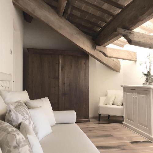 a bedroom with a white bed and a wooden ceiling at Le Case Di San Vitale in Ravenna