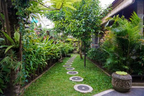 a garden with stepping stones in the grass at Three Brothers Guest House in Ubud