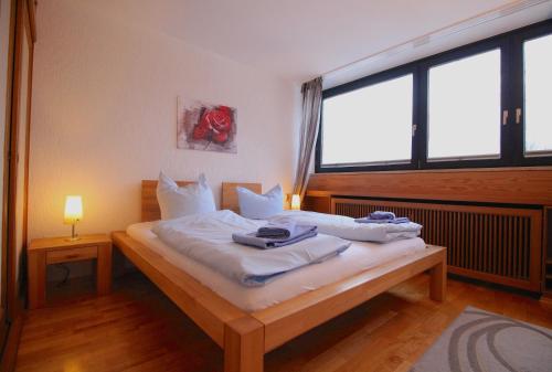 una camera da letto con letto, lenzuola e cuscini bianchi di Wettersteinblick a Garmisch-Partenkirchen
