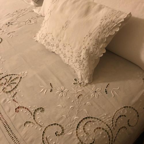 a bed with a white comforter and a pillow at Le Case Di San Vitale in Ravenna