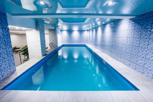 a swimming pool in a building with blue tiles at Renion Park Hotel in Almaty