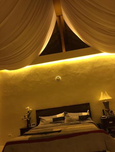 a bedroom with a bed with a ceiling with curtains at Cloud and Xky Beach Resort in Oslob
