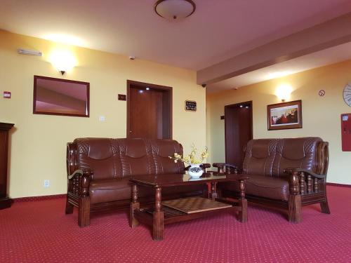 a living room with two leather chairs and a table at Willa Rawia 2 in Rewal
