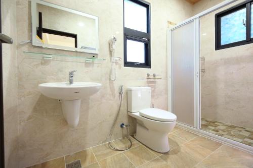 a bathroom with a toilet and a sink and a shower at 三匠獨棟庭園別墅 1歡唱烤肉打牌 -僅包棟 2聰明包棟-依人數提供床位及房間數 3寵物友善 4近夜市 in Jian