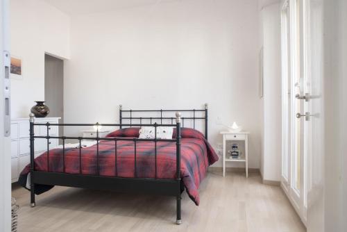 a bedroom with a black bed with a red blanket at Suite GG in Vatican in Rome