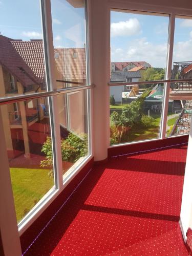 a room with two windows and a red carpet at Willa Rawia 2 in Rewal