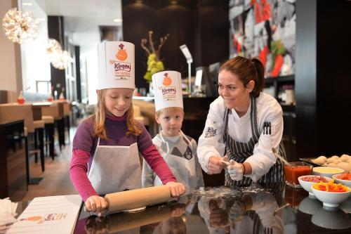 two girls in chefs hats are preparing food in a kitchen at Van der Valk Hotel Düsseldorf in Düsseldorf