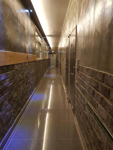 a hallway with brick walls and a hallway with doors at Maison de Geoje in Geoje 