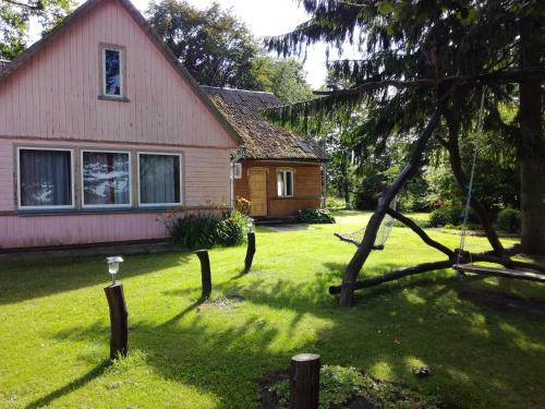 a house with a yard with a tree at Lauku viesu māja Bajāri in Rucava