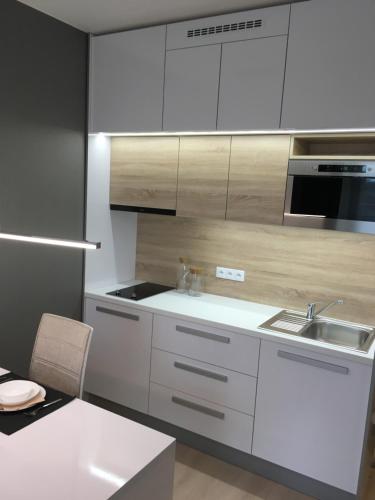 una cocina con armarios blancos y fregadero en Apartement Blanc de luxe, en Praga