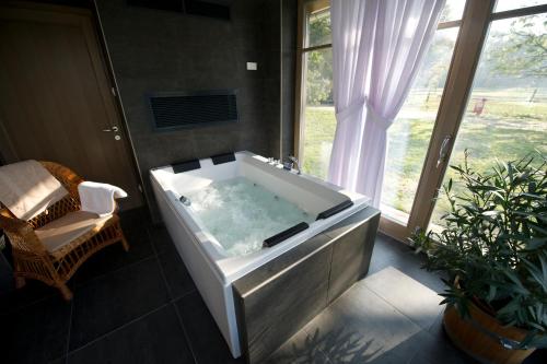 a large bath tub in a room with a window at Vadkert Major in Sárvár