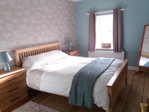 a bedroom with a large bed and a window at Archie's Rest in Drumshanbo