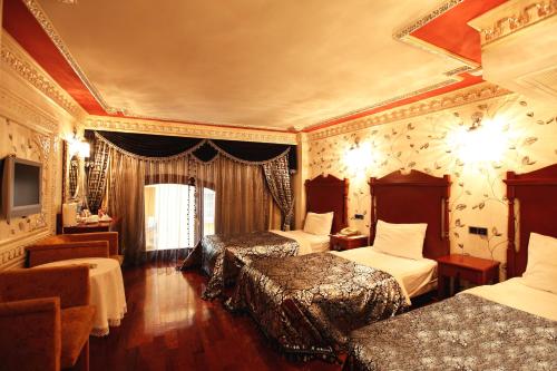 a hotel room with three beds and a television at Deluxe Golden Horn Sultanahmet Hotel in Istanbul