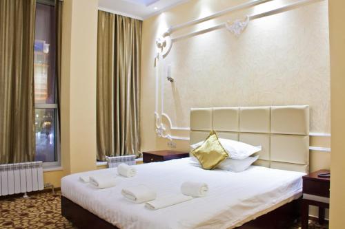 a hotel room with a bed with towels on it at Sky Luxe Hotel in Astana