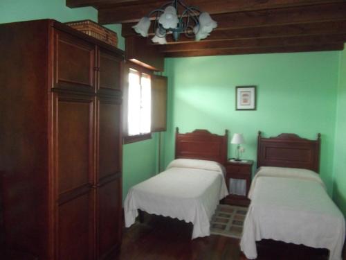 2 Betten in einem Zimmer mit grünen Wänden in der Unterkunft La Canaleja in Cigüenza